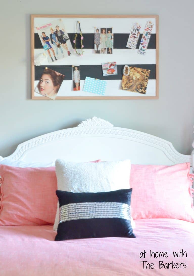 bedroom with striped cork bulletin board hanging above bed