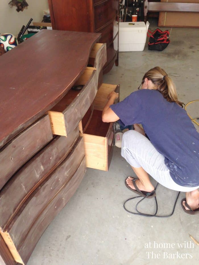 Sanding antique dresser before painting it.