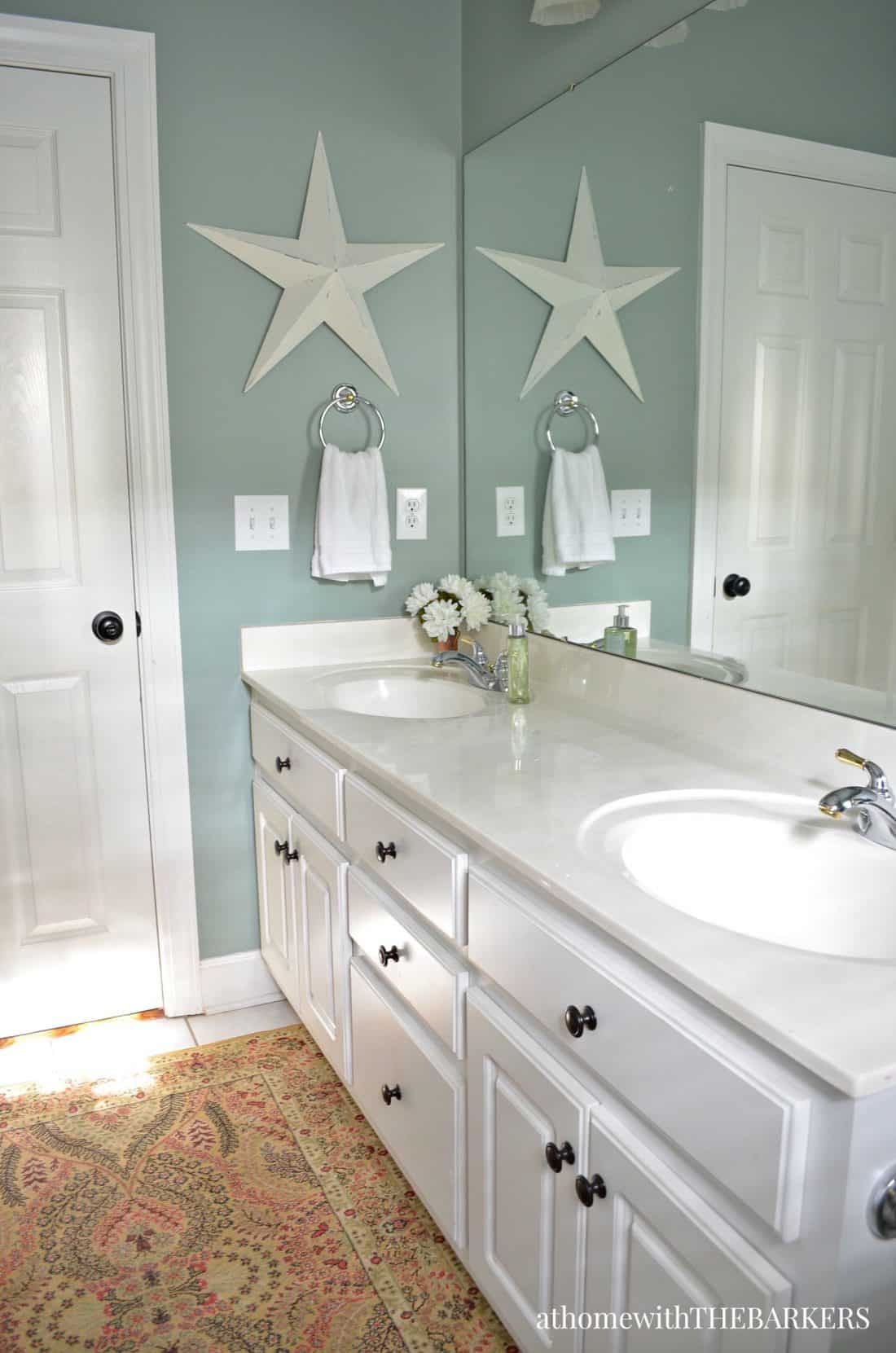 Green painted walls in a bathroom, semi gloss white painted cabinets