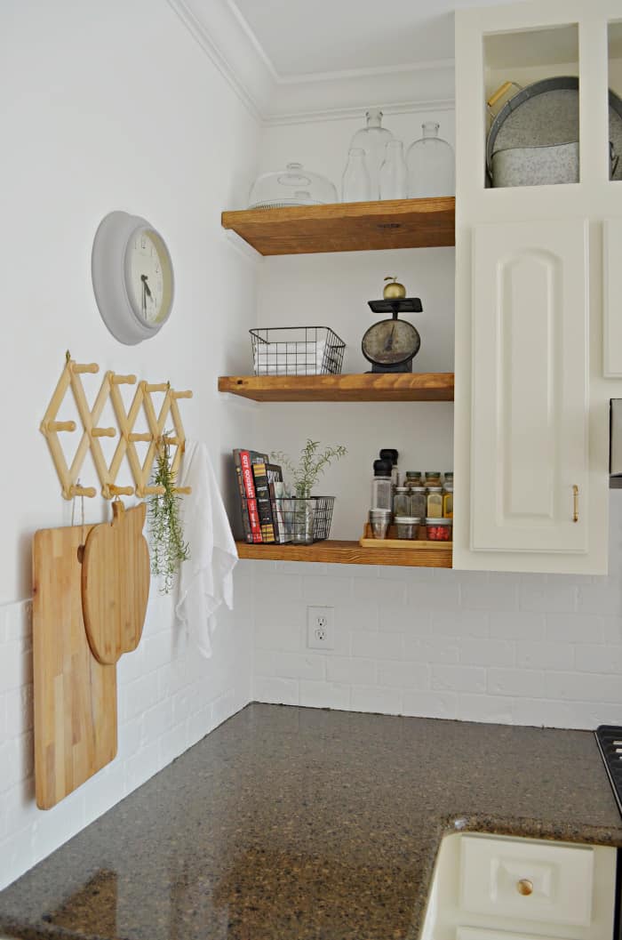 kitchen open shelves with spices, recipe books and hand towels.