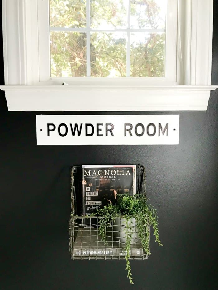 Bathroom painted black walls close up of hanging basket under window