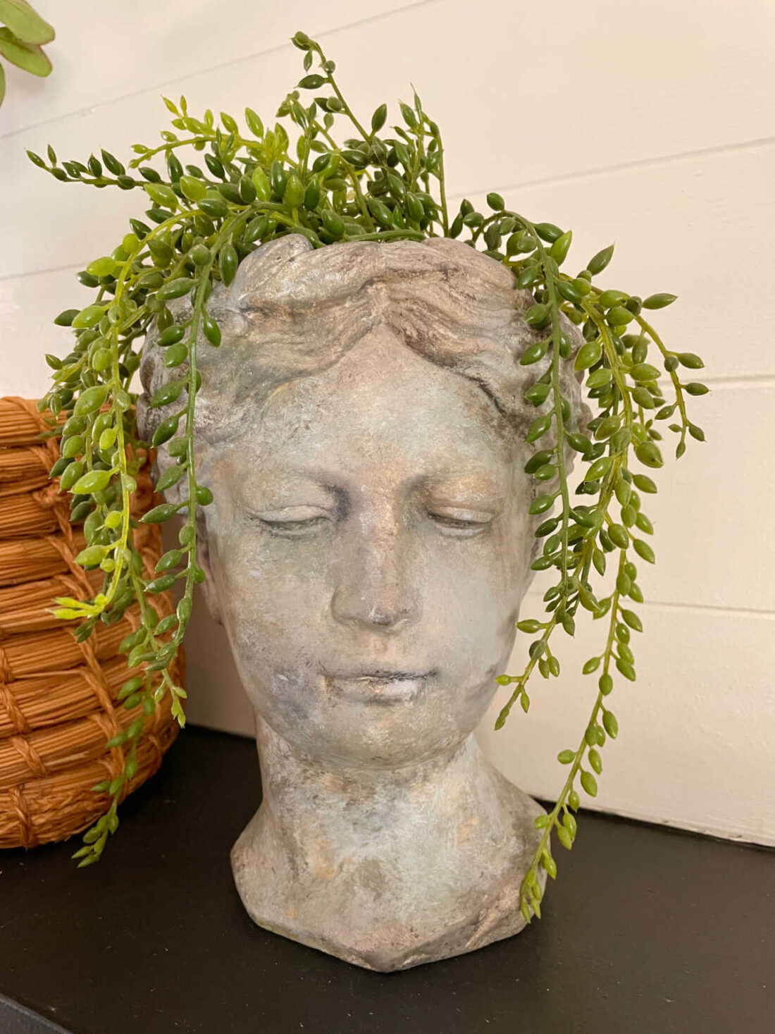 Aged concrete bust with faux greenery