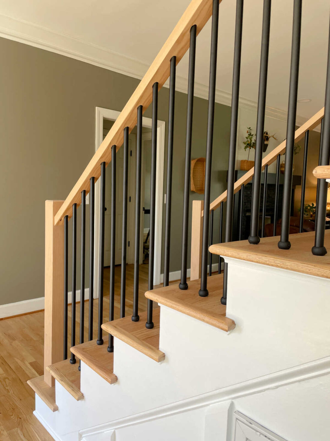 Foyer and staircase view into the living room with cozy wall color