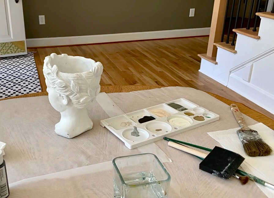 Bust pot and paint supplies on dining room table