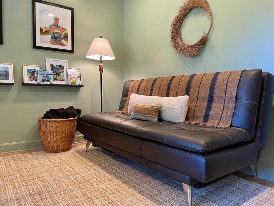 Clean and tidy home office with brown leather daybed for seating 