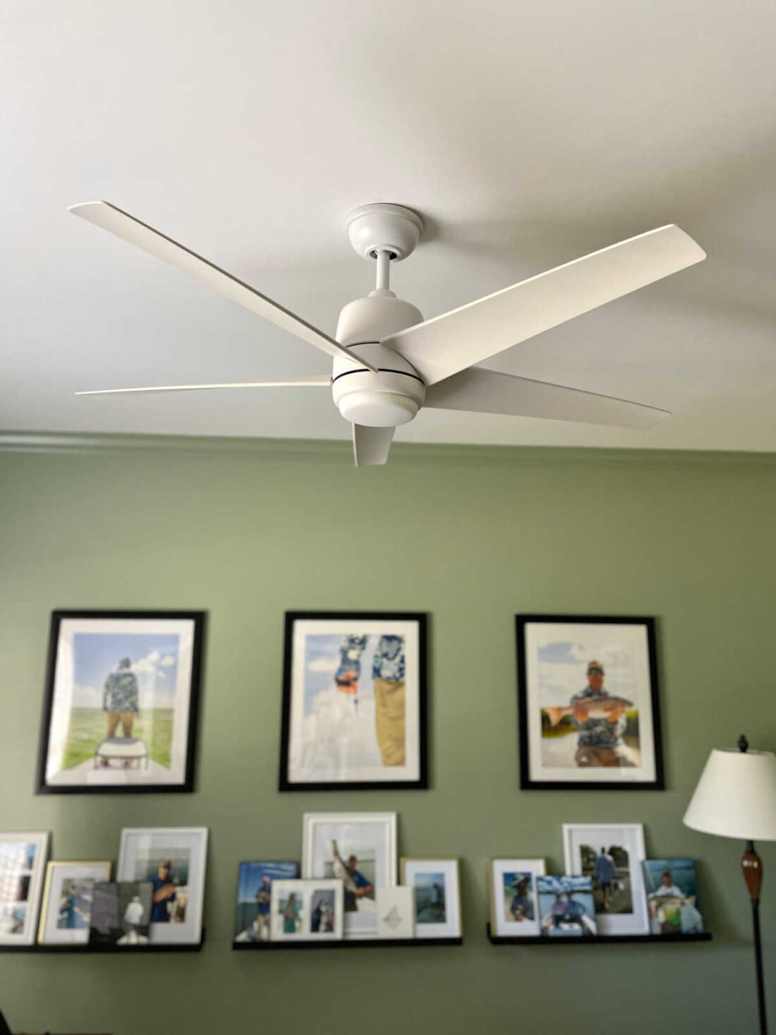 Home office photo wall decor with coastal plain paint color on walls and white ceiling fan
