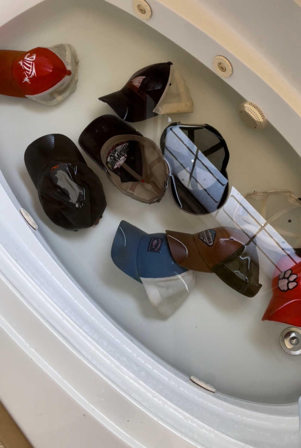 Laundry Stripping hats in clean water in bathtub