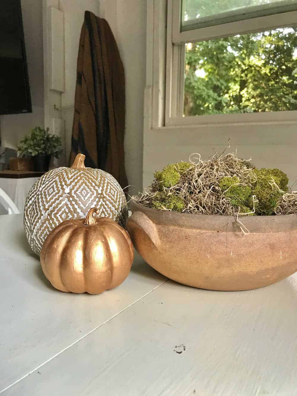 gold pumpkin styled on table with rub and buff wax