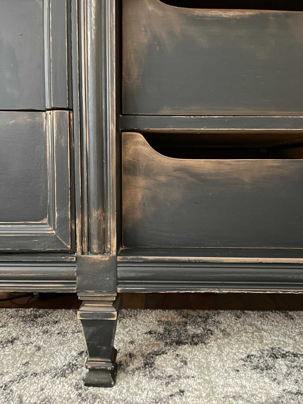 detail faux finish view of tv cabinet painted black with rub and buff aging