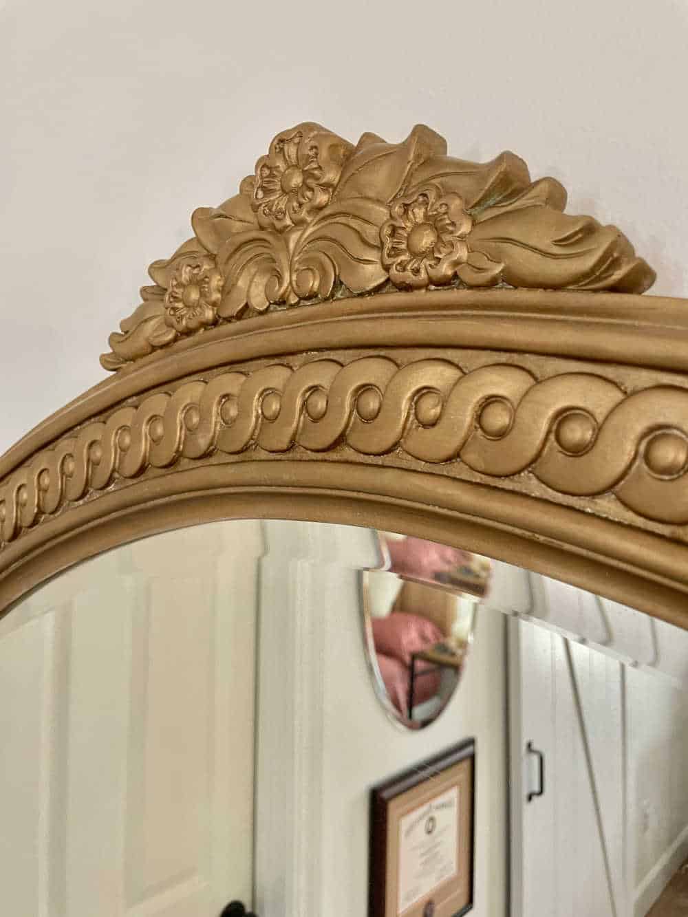 close up of mirror frame with flowers in antique gold run and buff
