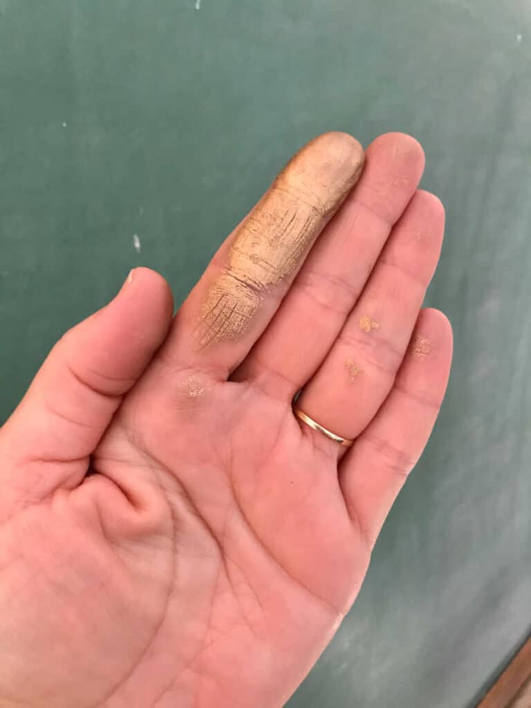 Hand with rub and buff on finger showing how to apply