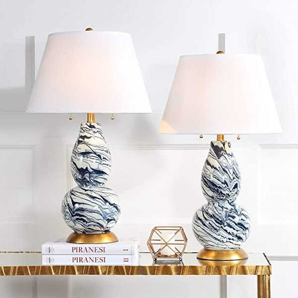 Two swirl painted table lamps on console table