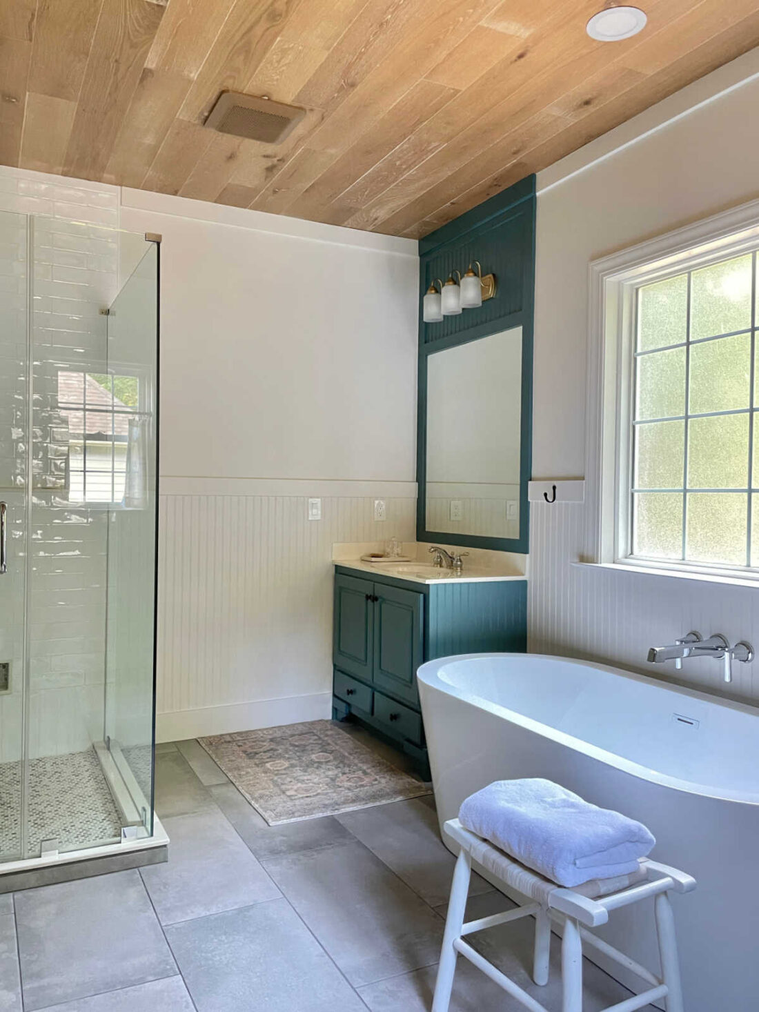 glass shower door, vanity and soaking tub in master bathroom remodel