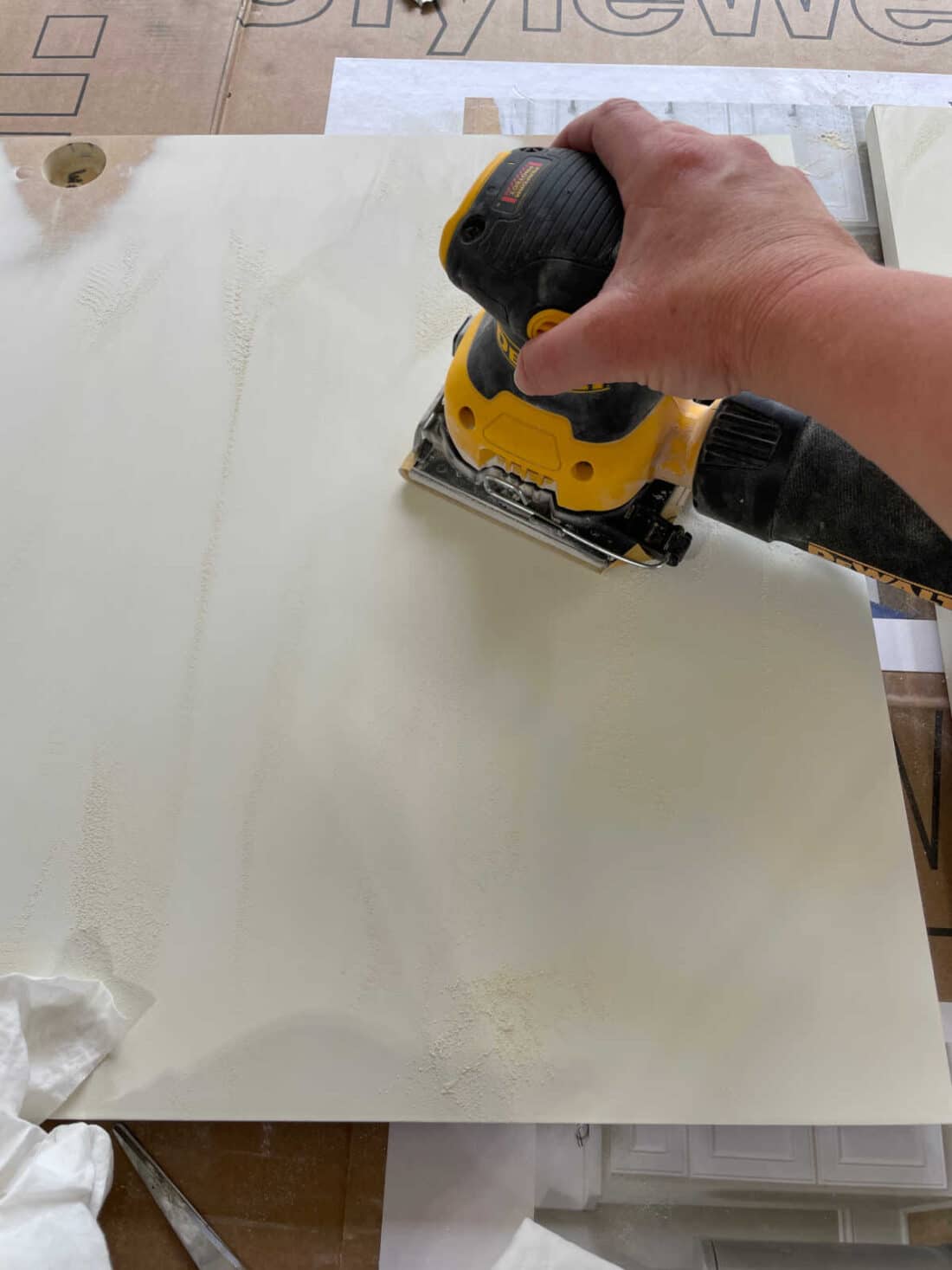 prep vanity doors by sanding with Dewalt electric sander