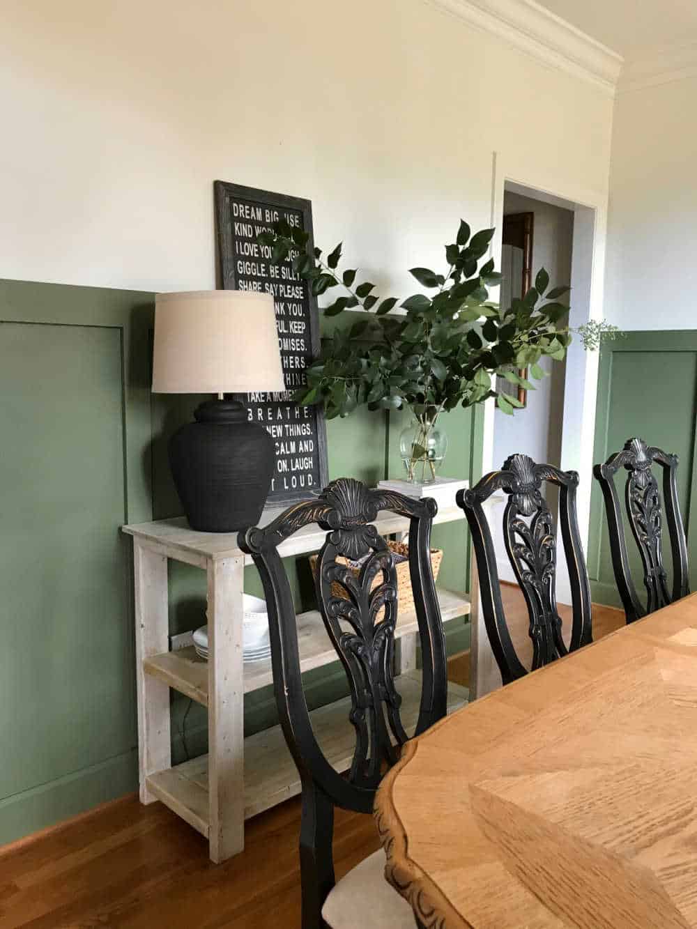 Dining room styled with black, tans and Oakmoss green wall